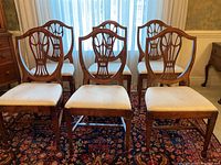 Front view of six chairs arranged in two rows before window