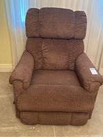 Front view of the brown recliner chair showing padded backrest and armrests.
