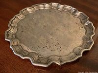 Top-down view of round tray showing scalloped edge and surface spotting