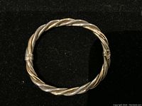 Overhead view of the twisted double cable bangle showing gold and silver cables