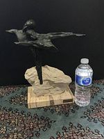 Front and side views of the signed Joseph Bofill bronze sculpture on rough stone and wood base with water bottle for scale.