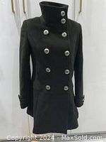 Front view of the black double-breasted AQUASCUTUM wool coat with high collar and silver-tone buttons buttoned up.