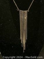 Front view of the waterfall necklace showing the cascading chains against a black background.