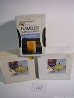 Two boxed flower presses and a box of flameless bayberry scented candle displayed together