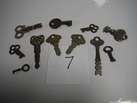 All keys displayed on a white surface including Ford car keys and several old vintage skeleton and clock keys.