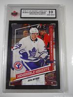 Front photo of 2016-17 Upper Deck hockey card showing Auston Matthews in Toronto Maple Leafs uniform with 'Memorable Moments' text and graded Gem Mint 10 by KSA.