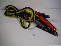 View of the entire booster cable showing red and black clamps and yellow and black cables.