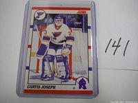 Front view shows Curtis Joseph in goalie gear with St. Louis Blues colors and logo, card number 141.