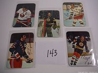 Five hockey cards on a white background showing different players in uniform with printed autographs.