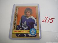 Two 1972-73 O-Pee-Chee Darryl Sittler hockey cards in protective plastic cases, showing front with player image and team logos.