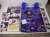 Photo showing the full collection including the book, poster, hockey gloves, two figurines, and hockey cards.