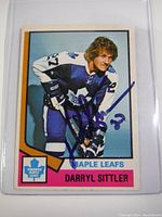 Front view of signed Darryl Sittler hockey card in protective sleeve.