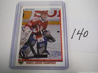 Front view of 1990 Upper Deck Felix Potvin rookie hockey card in protective plastic case, showing player in goalie stance with red uniform and pads.