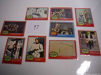 13 vintage Star Wars trading cards laid out, each card showing different scenes or characters from the 1977 OPC Series 1 and 2. Cards have a red border and yellow Star Wars OPC logo.