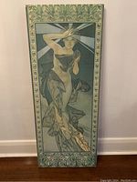 Front view of the tall rectangular wrapped canvas print showing a stylized woman figure with decorative border.