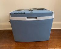 Front view of the Mobicool car cooler in gray-blue and white color, showing compact size and shape.