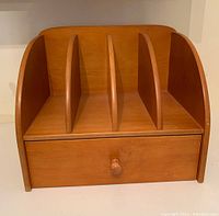 Front view of the wooden desk organizer showing four vertical dividers and one drawer with knob.