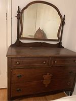 Front view of solid wood dresser with attached arched mirror and 4 drawers