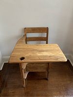 Frontal angled view of solid wood school desk with attached chair, showing desk surface with ink hole and drawer under seat.