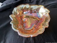 Amber marigold carnival glass dish shot from top showing its ruffled edges and iridescence.