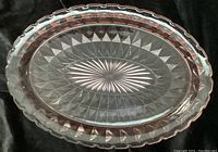 Top-down view of the pink oval depression glass platter showing scalloped edges and starburst center.