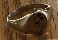 Close-up image of the ring face showing engraved black and white Mickey Mouse design on silver-tone metal.