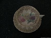 Top-down view of Paragon teacup and saucer showing floral design and gold trim on white porcelain.