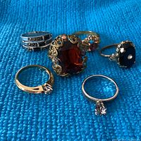 Photo showing all 6 rings on blue textured background for overall view