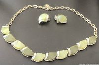 Overview photo showing the vintage thermoset choker necklace with linked pale green segments and textured silver-tone spacer bars, paired with matching clip-on earrings with complementary design.