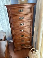 Front elevation showing seven flush-front drawers and brass bail pulls.