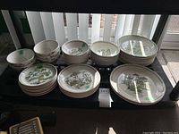 Assortment of bowls and plates in various sizes arranged on table under window
