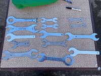Top view of 14 bike repair wrenches laid out on a textured surface