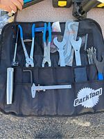 Full view of the tool kit laid out in the open, showing various bike repair tools including caliper and pliers in a black fabric case with the Park Tool logo.