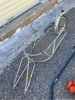 Full view of YAK cargo bike trailer showing tubular frame and mesh cargo rack on single wheel.