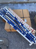 Blue and white ReadyJump jump standards and bundled red/white poles on cardboard box