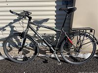 Full side view of matte grey Specialized Hardrock mountain bike against wall showing overall condition and accessories