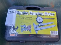 Closed black hard plastic carrying case with printed label showing IceToolz Xpert series spoke tension meter image, branding, and key features including dial indicator and 0.01 mm scale precision.