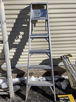 Front view of the aluminum step ladder showing the five steps and top platform with tool tray.