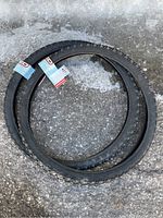 Photo of two new 26 inch studded bike tires laid on ice showing tags attached
