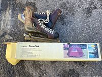 Photo shows vintage size 12 leather ice skates placed on box of 3-person dome tent.