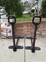 Two Couch Cane assist devices standing side-by-side outdoors with packaging in background