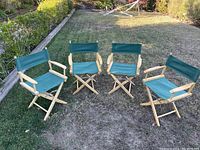 Four director's chairs with solid beechwood frames and green canvas seats and backrests arranged outdoors on grass.
