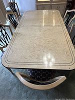 Photo showing the top view of the rectangular dining table with patterned surface and chairs around it.