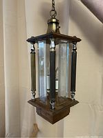 Front and side view showing brass top, wood frame, beveled glass, and interior candle bulb fixtures.