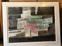 Full view of abstract modern art piece displaying textured acrylic blocks in black, white, pink, turquoise, and orange. Painted on a textured surface with cracking effects, matted with white mat and black frame.