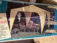 Photo of the boxed gazebo showing assembled gazebo with outdoor furniture underneath.