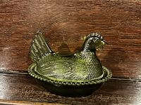 Top view of the vintage green glass chicken dish showing detailed textured feather design and overall shape.