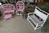 Full set of wooden doll furniture including pink rocking chair with floral decorations, pink settee, white and brown willow settees, small brown willow armchair with heart accents, and a small pink coffee table, displayed on a table