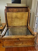 Front view of antique wooden accounting box with glass top and yellow insert underneath lid
