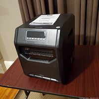 Shows the front and side view of the black Omni Max infrared quartz heater, highlighting the control panel and heating grille.